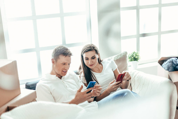 happy young couple looking at their smartphone screen . - Fotoğraf, Görsel
