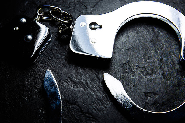 Police métal vraies menottes sur le fond noir. Crime et cambriolage, concept de prison. - Photo, image