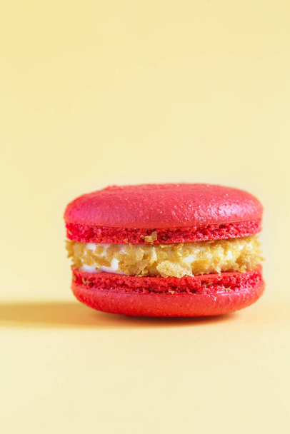 piros torta macaron vagy makaróni sárga alapon. színes mandulás sütik. Francia makarónis torta közelről. Macaroons színes háttér - Fotó, kép