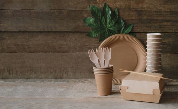 Eco craft paper tableware. Eco plates on a wooden background. Recycling concept is environmentally friendly. Banner. Copy space - Фото, изображение