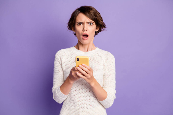 Photo portrait of angry misunderstanding female student reading fake news cellphone isolated on bright purple color background - Foto, Bild