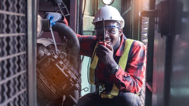 Afrikaanse engineering motor machine controller controleren, werken met walk radio communicatie of walkie-talkie in kamer-systeem in de industrie - Foto, afbeelding
