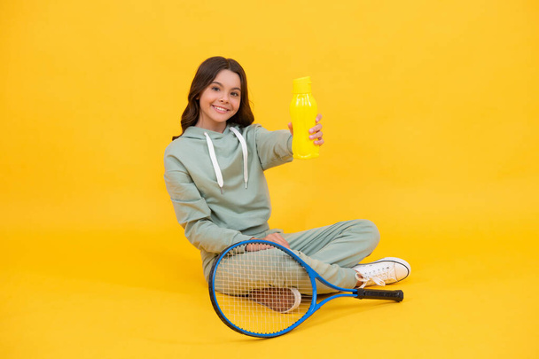 child with tennis racquet. teen girl drink water after sport training. badminton player relax. healthy and active lifestyle. happy childhood. be hydrated. kid sit with racket and water bottle. - Φωτογραφία, εικόνα