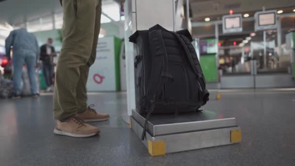 Passagier in masker zelf-check-in bagage voor vlucht in machine in terminal, reis veiligheidsconcept, nieuwe normale, sociale afstand tijdens coronavirus uitbraak. Man gebruik self service check-in op de luchthaven - Video