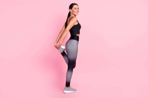 Photo of confident adorable young woman dressed sportive outfit smiling stretching isolated pink color background - 写真・画像