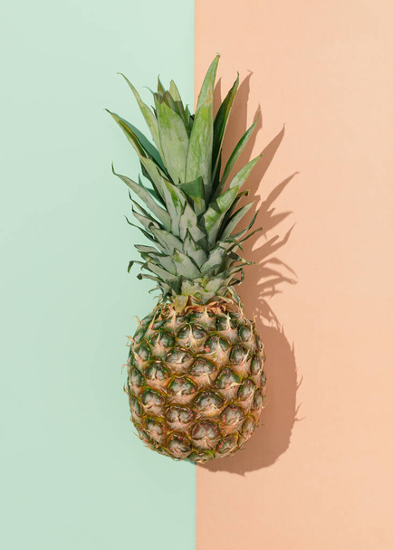 Nane yeşili ve parlak terracotta arka planında güneşli bir gün gölgesi olan taze ananas meyvesi. En az egzotik gıda konsepti. - Fotoğraf, Görsel