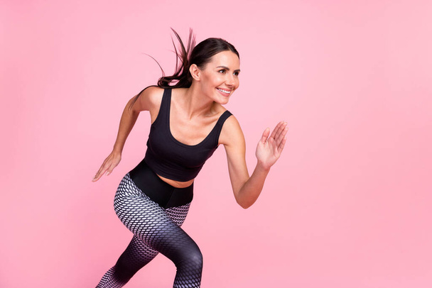 Profile side photo of young sporty woman happy positive smile run fast cross workout isolated over pastel color background - Φωτογραφία, εικόνα
