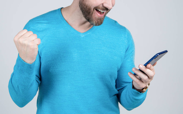 happy man with beard watching and reading smartphone, mobile device. - Fotoğraf, Görsel