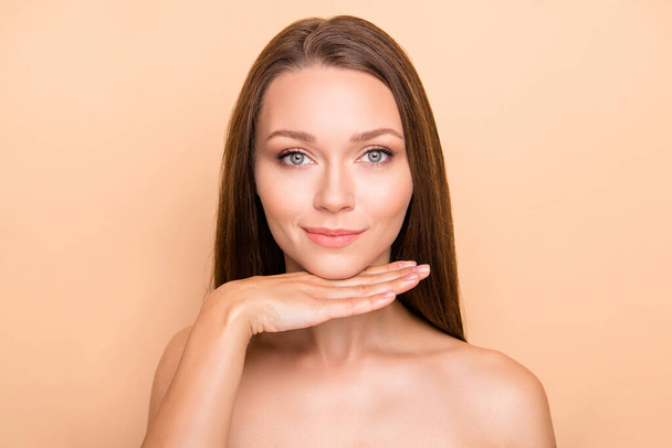 Photo of young girl hand under chin enjoy spa therapy lifting hydration isolated over beige color background - Zdjęcie, obraz