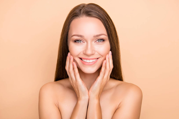 Portrait of pretty cheerful girl touching soft shine skin domestic procedure isolated over beige pastel color background - Photo, Image