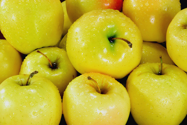 Manzanas amarillas cubiertas con gotas de agua en el mercado
. - Foto, Imagen