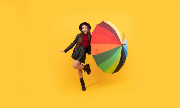 happy teen girl in hat and leather clothes having fun with rainbow umbrella, autumn fun. - Zdjęcie, obraz