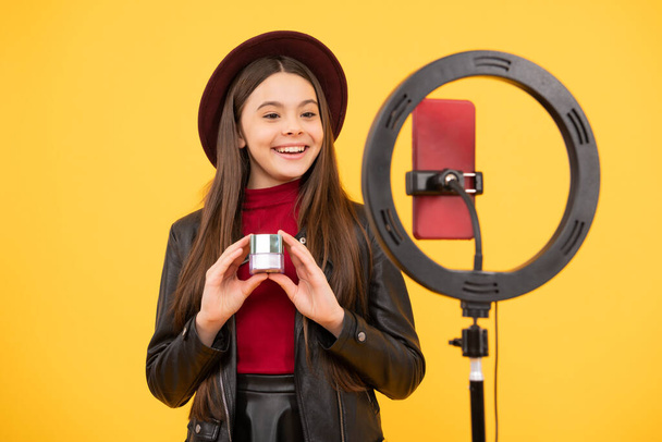 ευτυχής έφηβος blogger κορίτσι χρησιμοποιούν selfie οδήγησε λαμπτήρα και smartphone στο τρίποδο για την κατασκευή online βίντεο tutorial ομορφιά blog παρουσίαση καλλυντικά μακιγιάζ, vlogging. - Φωτογραφία, εικόνα