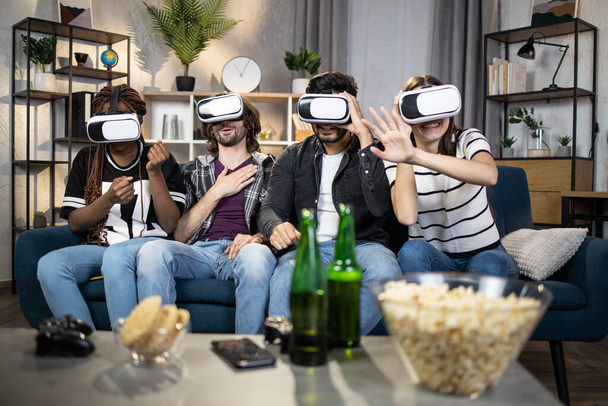 Multi ethnic friends using virtual headset at living room - Photo, Image