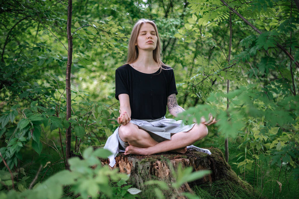 Practice of meditation and interaction with nature. Girl in green forest - Photo, Image