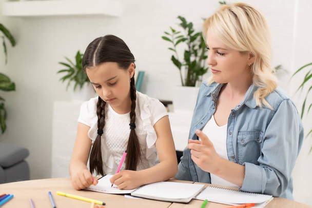 Mutter hilft ihrer Tochter bei den Hausaufgaben - Foto, Bild