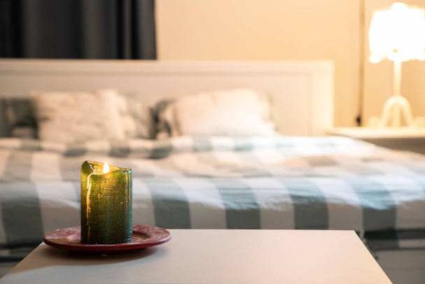 ζεστή κρεβατοκάμαρα λεπτομέρεια επικεντρωθεί στην καύση κερί - Φωτογραφία, εικόνα