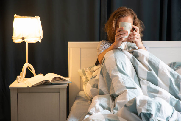 mujer con café o taza de té en la cama descanso nocturno - Foto, Imagen