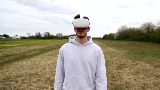 Bir çocuk açık hava sahasında sanal gerçeklik kulaklıklarıyla yürüyor. - Video, Çekim