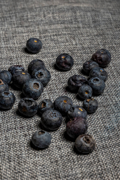 Handful of very ripe blueberries on top of a gray cotton cloth - Photo, Image