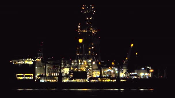Gece lambalı açık deniz petrol platformu. Petrol sondajı ham petrol sondajı kıta sahanlığı sabitleme platformu insan yapımı yüzer mavna rampası rampası sanayi platformu depolama kulesi enerjisi 4K - Video, Çekim