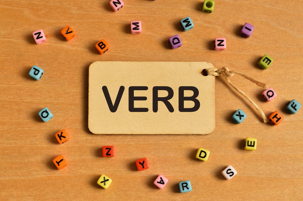 Κάτοψη της πολύχρωμες χάντρες αλφάβητο και ετικέτα ετικέτα γραμμένο με VERB. Εκπαιδευτική έννοια. - Φωτογραφία, εικόνα