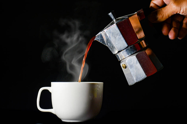Kırpılmış insan görüntüsü fincana kahve dolduruyor. - Fotoğraf, Görsel