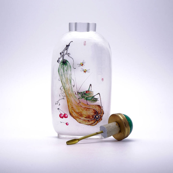 Antique snuff bottle isolated on white background. Inside painted snuff bottle (Neihua-Biyanhu) with cricket and bee. Famous Chinese arts and crafts :  - Photo, Image
