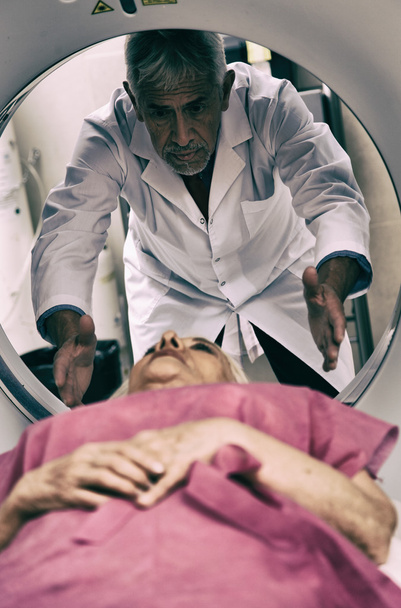 Médico principal que examina a una mujer en los años 70 con escáner CT
 - Foto, imagen