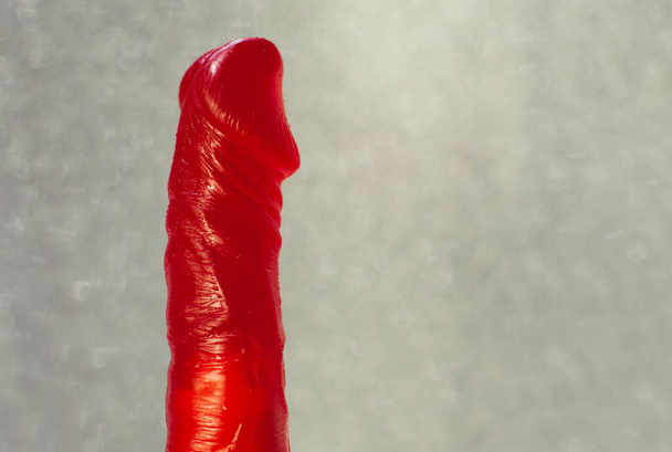 Red vibrator made of gel on a gray background. - Photo, Image