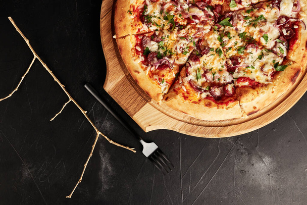піца на дерев'яній основі на чорному текстурованому тлі вид зверху
 - Фото, зображення