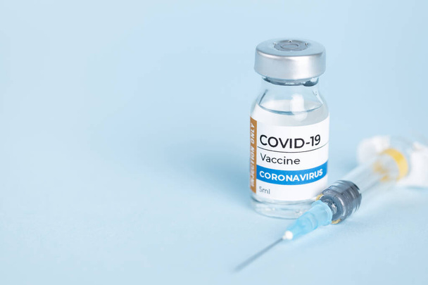 Coronavirus Covid-19 Flacon de vaccin flacon et seringue en verre sur fond bleu - Photo, image