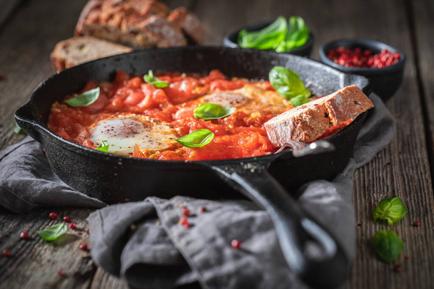 Shakshuka with eggs and tomatoes on pan. Perfect for breakfast. Tunisian cuisine.  - Foto, immagini
