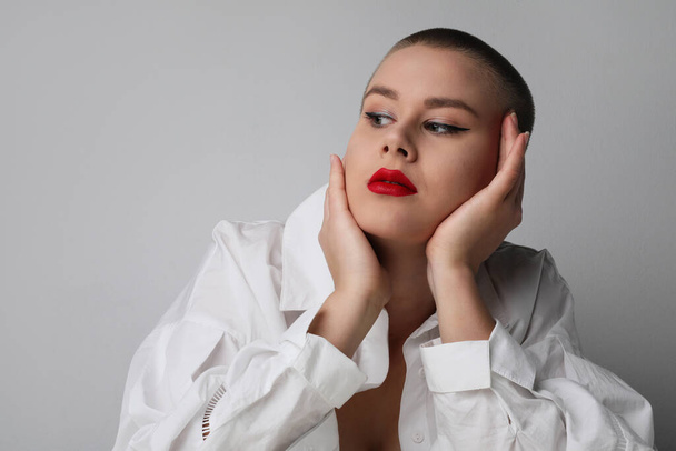 Young bald woman looking aside, posing in the studio. Isolated. - Фото, зображення