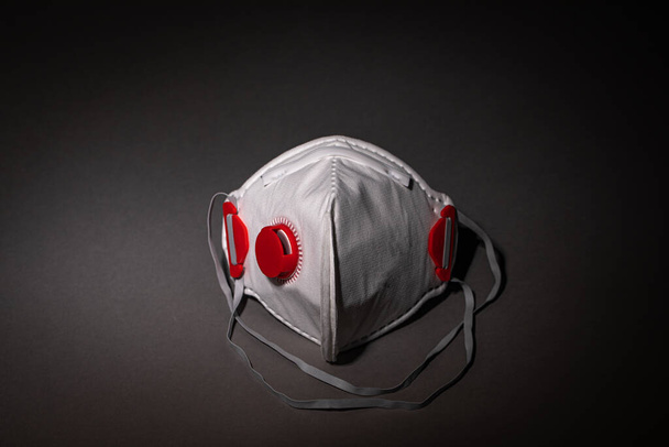 maschera di sicurezza - maschera respiratoria - respiratore su sfondo scuro - covid-19 - Foto, immagini