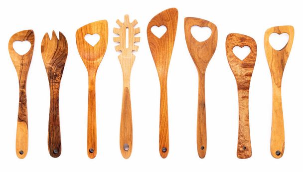 Různé tvary srdce z dřevěných kuchyňských potřeb. Dřevěné lžíce a dřevěné špachtle izolát na bílém pozadí. - Fotografie, Obrázek