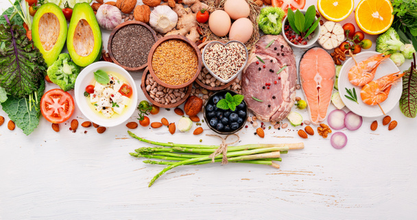 Ketogene lage koolhydraten dieet concept. Ingrediënten voor gezonde voeding selectie opgezet op witte houten achtergrond. - Foto, afbeelding