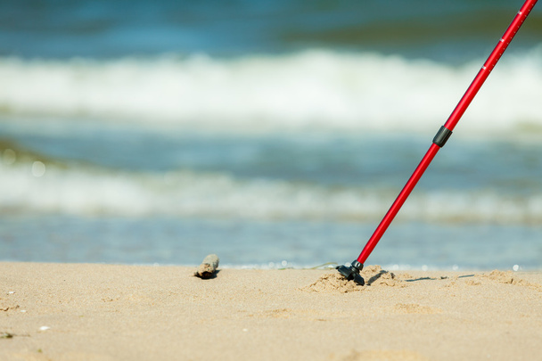 Nordic walking. Red sticks on the sandy beach - Fotoğraf, Görsel