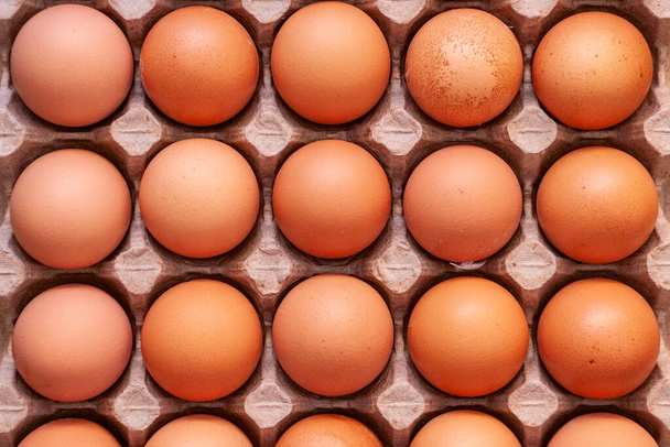 Φρέσκα ωμά αυγά κοτόπουλου σε χαρτόκουτο. Καφέ, πάνω όψη, δεκαπέντε ολόκληρα αδιάσπαστα κομμάτια - Φωτογραφία, εικόνα