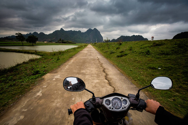 Beautiful landscape with motorbike in Van Long Nature Reserve, Tam Coc, Ninh Binh in Vietnam. Rural scenery photo taken during driving  in south east Asia. - Foto, Imagen