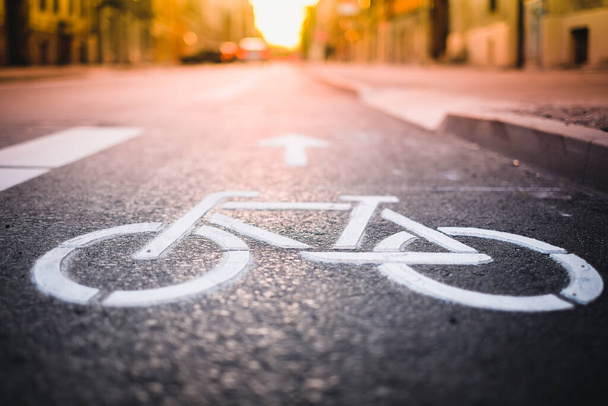 Erillinen pyörätie polkupyörille. Valkoinen polkupyörän symboli tiellä. Valikoiva painopiste - Valokuva, kuva