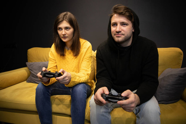 pareja jugando videojuegos en el sofá. Estilo de vida nocturno entretenimiento familiar - Foto, imagen