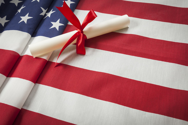 Ribbon Wrapped Diploma Resting on American Flag with Copy Space - Fotoğraf, Görsel