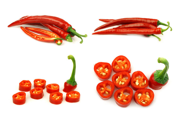 rode chilipepers (Capsicum) en enkele gesneden pepers op een witte achtergrond - Foto, afbeelding
