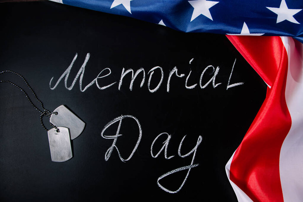 USA Memorial Day concept (en inglés). Bandera americana y placas de identificación sobre fondo negro. Letras manuscritas en pizarra. - Foto, imagen