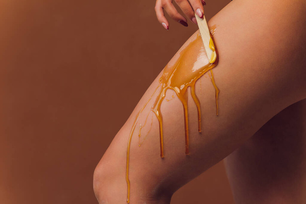 Hair removal with sugar. In the office of a cosmetologist. - Φωτογραφία, εικόνα