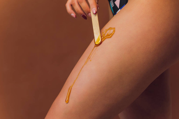 Hair removal with sugar. In the office of a cosmetologist. - 写真・画像