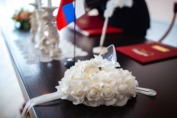 Auf dem Kopfkissen liegen wunderschöne Eheringe. die Braut am Hochzeitsmorgen bereitet sich darauf vor, Ehefrau zu werden. Hochzeitszeremonie, mit Ringen in der Hand - Foto, Bild