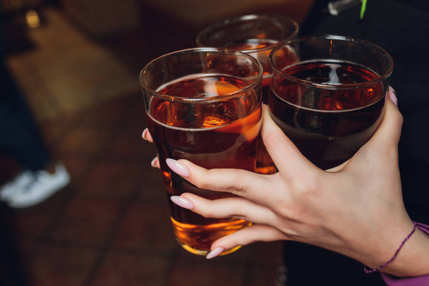 Woman holding three glasses of beer bartender. - Фото, изображение