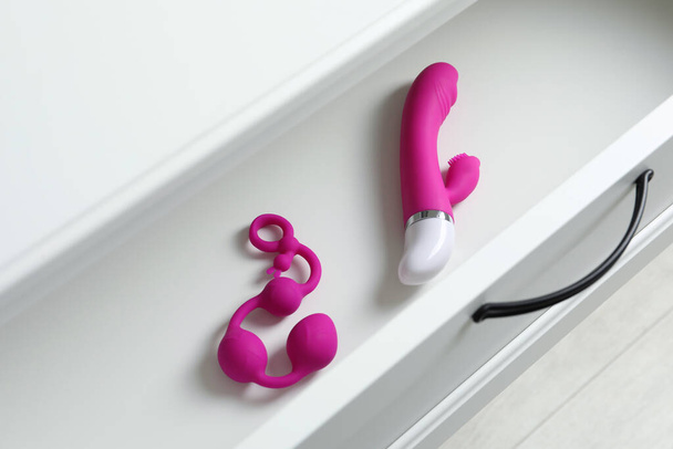 Modern vibrator and anal balls in open white drawer, above view. Sex toys - Фото, зображення